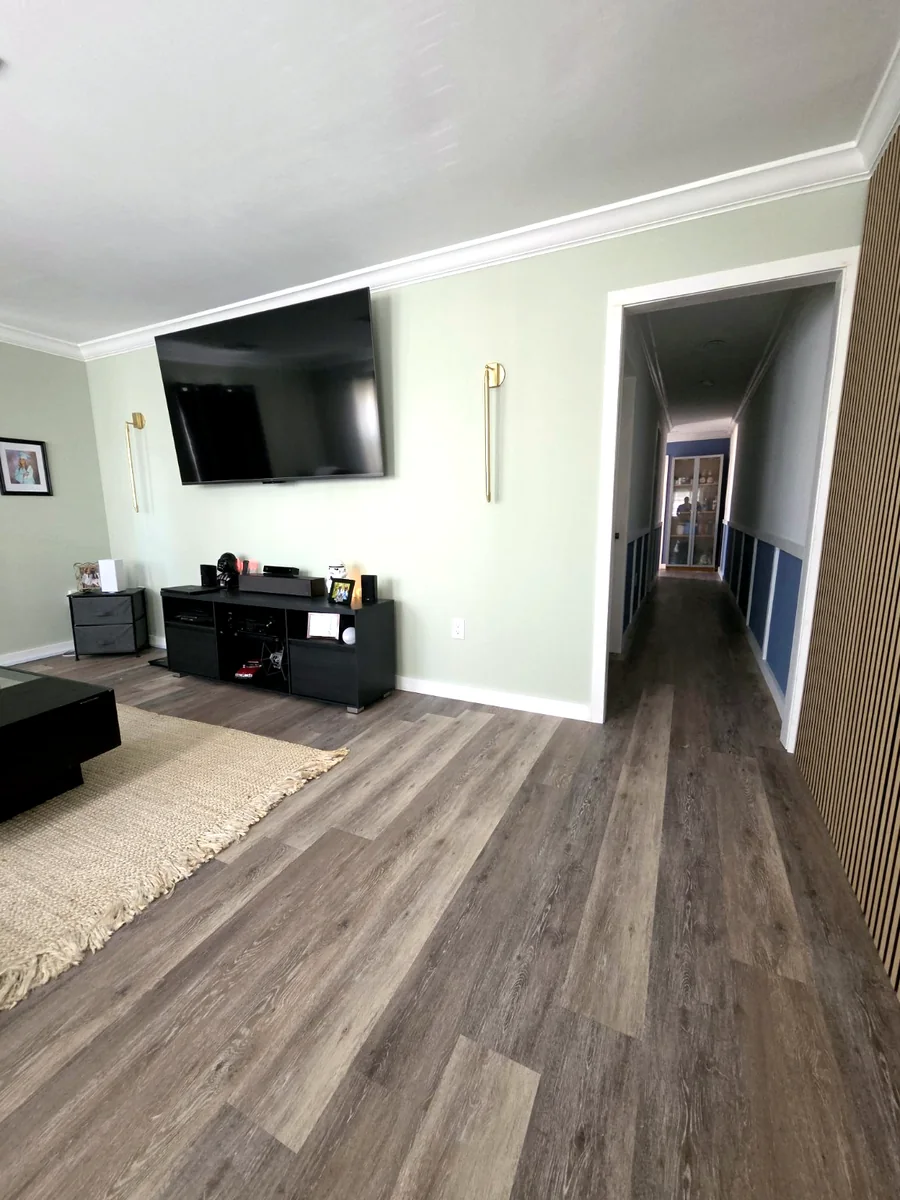 Updated living room with new flooring paint lighting mounted TV and acoustic wall